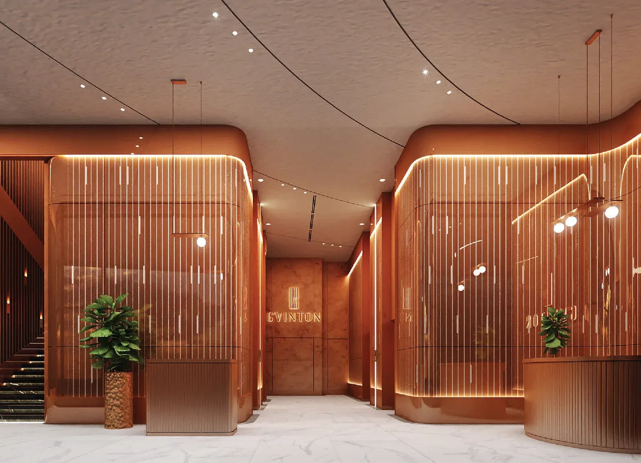 Double-height lobby with copper-tone screens and marble flooring