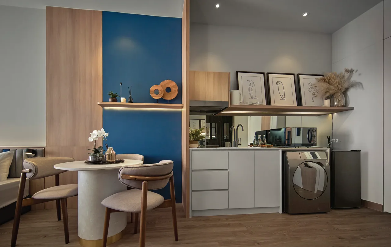 Compact kitchen and dining area with washer, fridge and two-seat dining