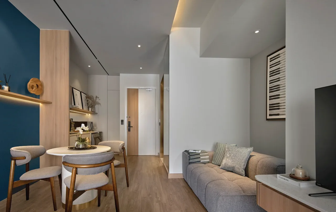 Open-plan suite with sofa, dining, kitchenette and floor-to-ceiling glazing